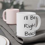 I'll Be Right Back Ceramic Mug on a grey tablecloth